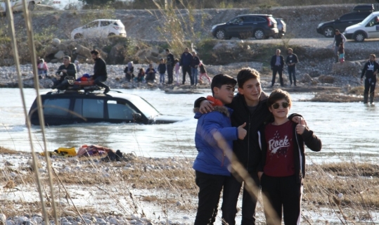 Kanalın ortasında mahsur kalan aracın önünde poz verdiler