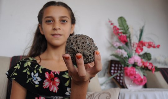 Küçük kız deniz kenarında bulduğu taşın göktaşı olduğunu söylüyor